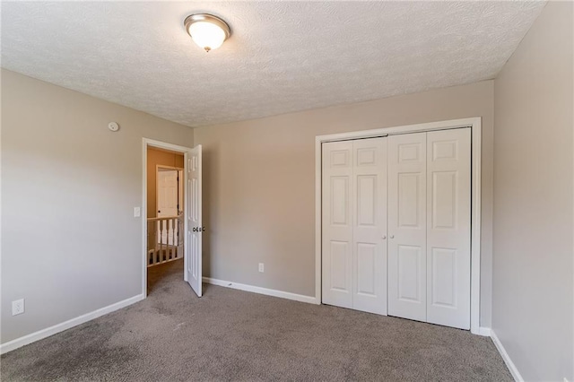 unfurnished bedroom with a closet, a textured ceiling, and carpet floors