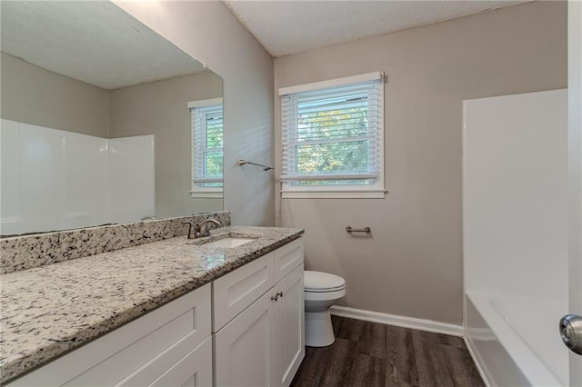 full bathroom featuring hardwood / wood-style flooring, a textured ceiling, vanity, toilet, and shower / bathtub combination