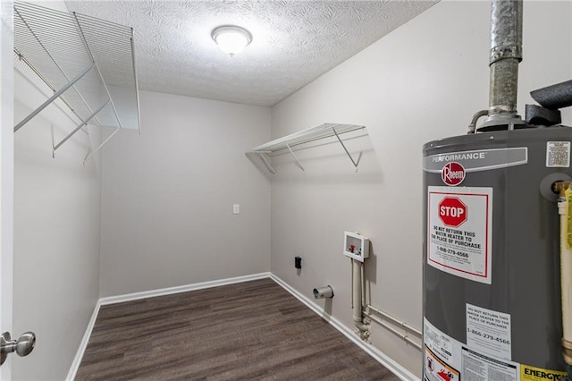 clothes washing area featuring gas water heater, a textured ceiling, electric dryer hookup, dark wood-type flooring, and hookup for a washing machine