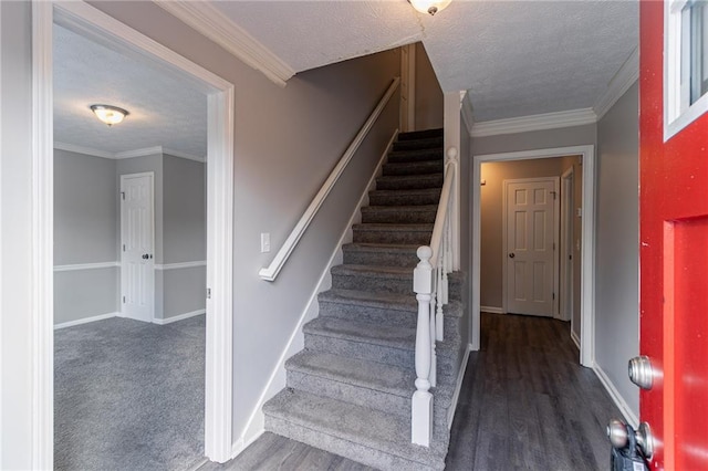 stairway featuring wood-type flooring, a textured ceiling, and crown molding