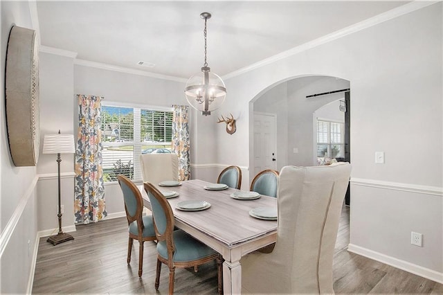 1329 Old Glory Ct, Hoschton, GA 30548 - dining space featuring arched walkways, wood finished floors, plenty of natural light, and ornamental molding