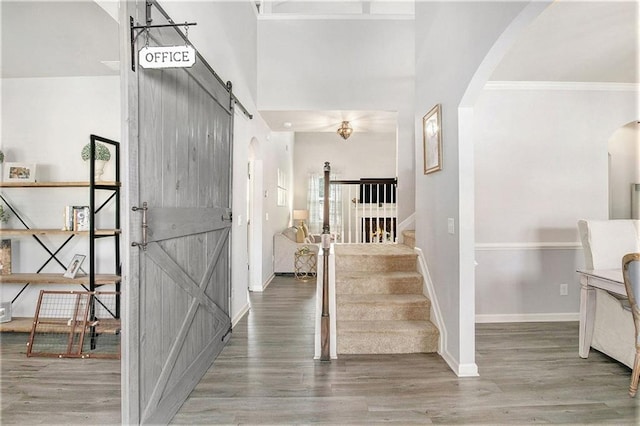 1329 Old Glory Ct, Hoschton, GA 30548 - entryway featuring arched walkways, wood finished floors, stairs, a barn door, and ornamental molding
