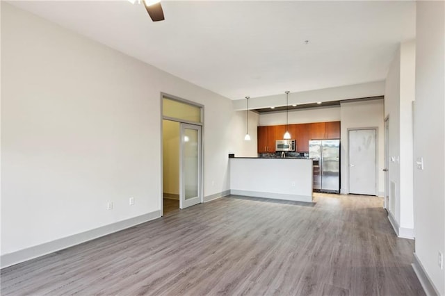 unfurnished living room with hardwood / wood-style floors and ceiling fan