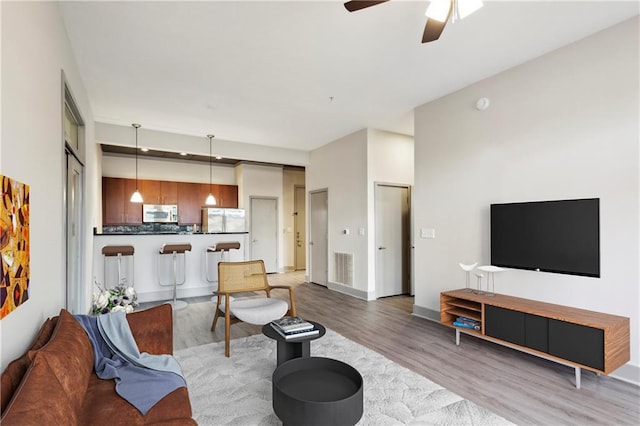 living room featuring ceiling fan and light hardwood / wood-style floors