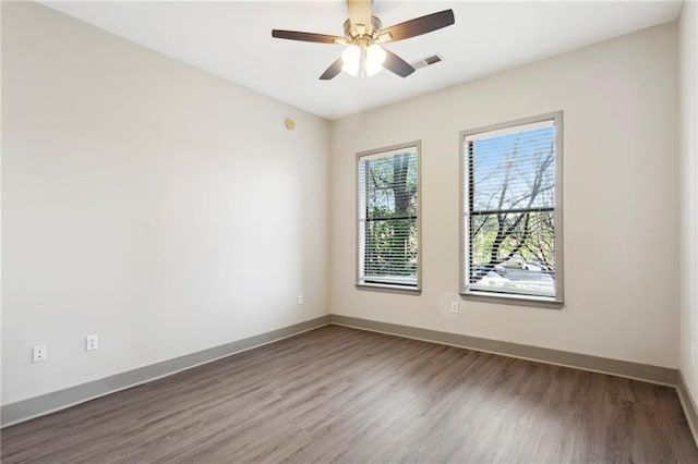 spare room with hardwood / wood-style floors and ceiling fan