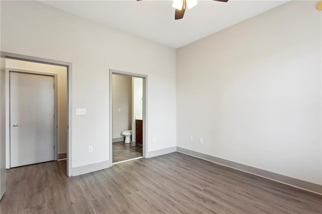 unfurnished bedroom featuring connected bathroom, ceiling fan, and wood-type flooring