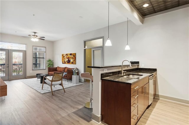 kitchen featuring kitchen peninsula, stainless steel dishwasher, ceiling fan, sink, and pendant lighting