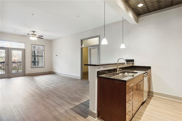 kitchen with kitchen peninsula, sink, stainless steel dishwasher, and light wood-type flooring