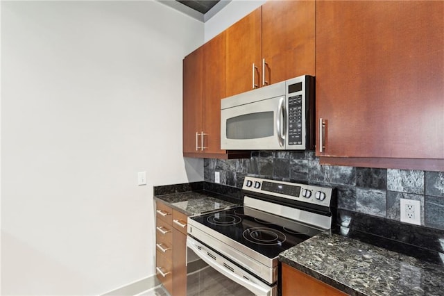 kitchen featuring stainless steel appliances, tasteful backsplash, and dark stone countertops