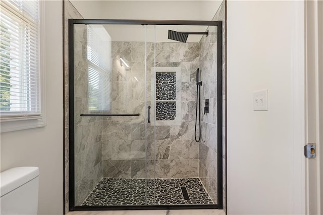 bathroom featuring toilet and an enclosed shower