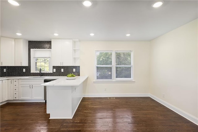 kitchen featuring white cabinetry, dark wood-type flooring, decorative backsplash, and kitchen peninsula