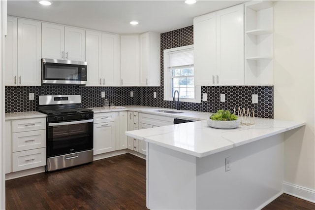 kitchen featuring white cabinetry, appliances with stainless steel finishes, sink, and kitchen peninsula