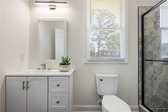 bathroom with vanity, a shower with shower door, and toilet