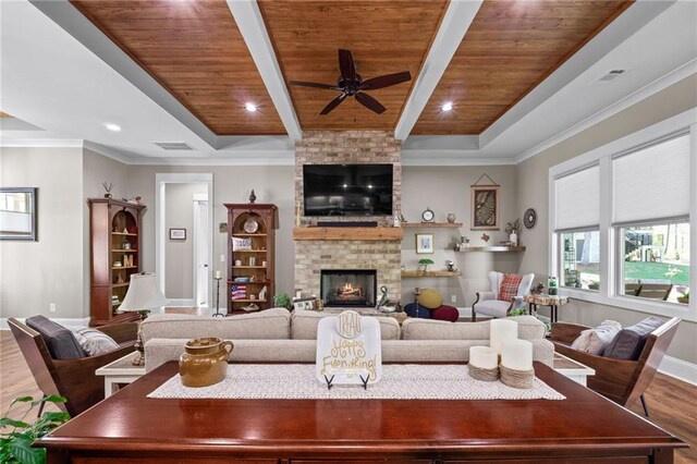 living room featuring crown molding, wood ceiling, wood-type flooring, and a brick fireplace