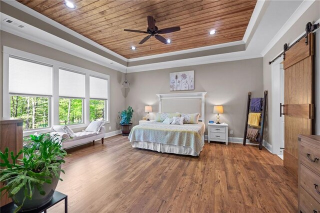 bedroom with wood ceiling, dark hardwood / wood-style floors, a tray ceiling, a barn door, and ceiling fan