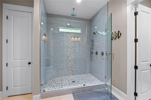 bathroom with an enclosed shower and tile patterned floors