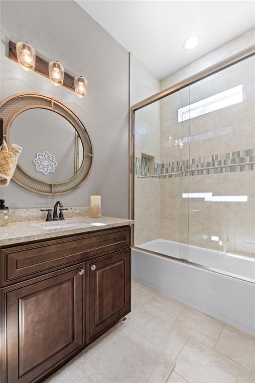 bathroom featuring vanity, combined bath / shower with glass door, and tile patterned flooring