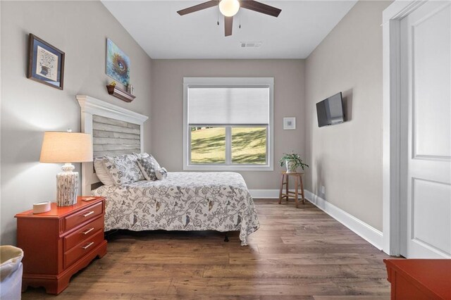 bedroom with ceiling fan and dark hardwood / wood-style flooring