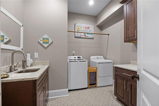 clothes washing area featuring washer and dryer, cabinets, and sink