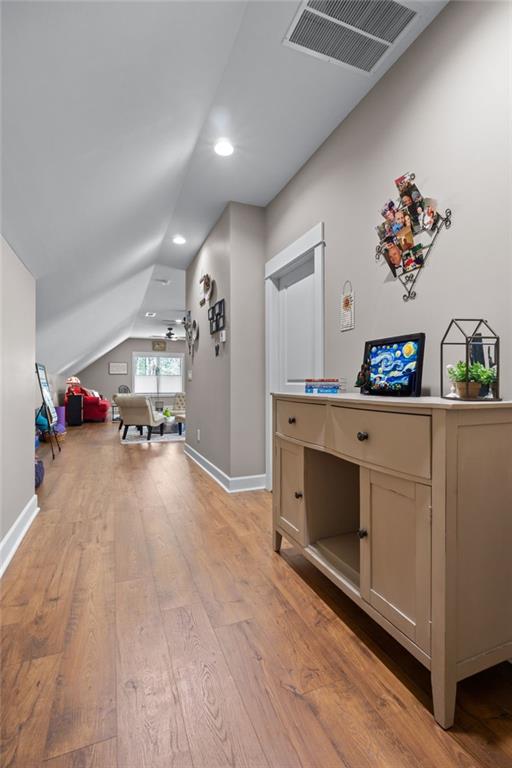 interior space featuring lofted ceiling and light hardwood / wood-style flooring