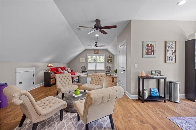 living room featuring lofted ceiling, light wood-type flooring, and ceiling fan