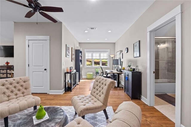 living room with light hardwood / wood-style flooring and ceiling fan