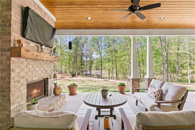 view of patio featuring an outdoor living space with a fireplace and ceiling fan