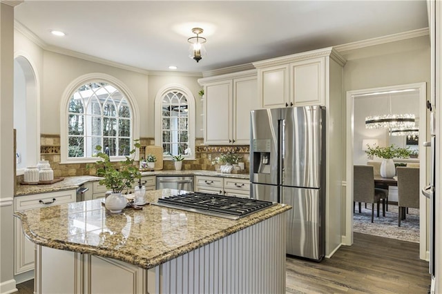 kitchen featuring dark wood-style floors, appliances with stainless steel finishes, backsplash, and light stone counters