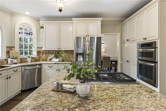 kitchen featuring appliances with stainless steel finishes, dark wood finished floors, ornamental molding, and tasteful backsplash