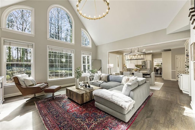 living area featuring a chandelier, a healthy amount of sunlight, baseboards, and dark wood-style floors