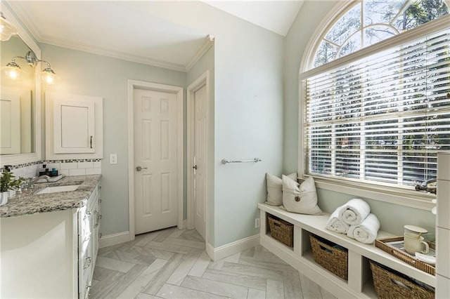 bathroom with vanity, baseboards, and ornamental molding