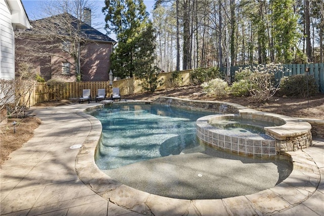 view of pool featuring a fenced backyard, a pool with connected hot tub, and a patio