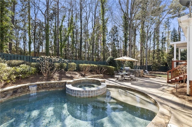 view of swimming pool with a fenced backyard, a pool with connected hot tub, outdoor dining area, and a patio