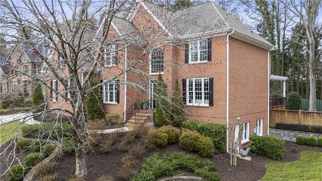 exterior space featuring brick siding and fence