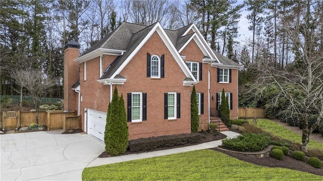 view of front of property featuring driveway, a chimney, fence, and brick siding