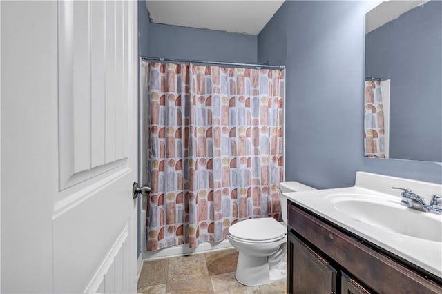 full bathroom with toilet, stone finish flooring, a shower with shower curtain, and vanity