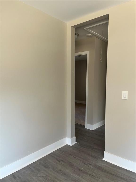 unfurnished room with dark hardwood / wood-style flooring