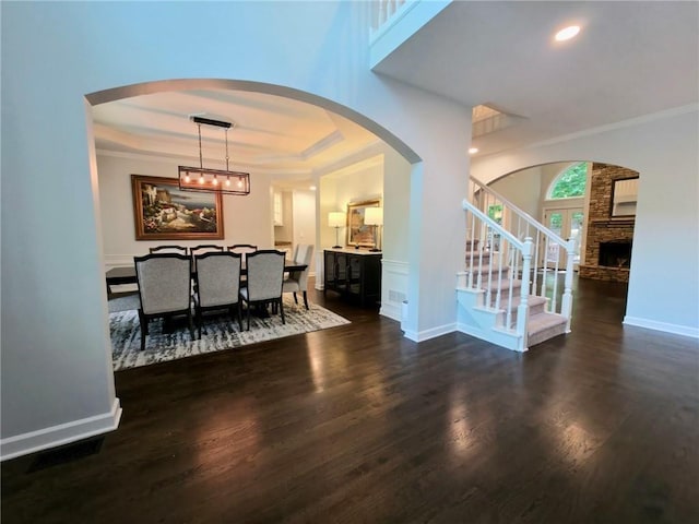 1045 River Pt, Suwanee, GA 30024 - foyer featuring a raised ceiling, stairway, crown molding, wood finished floors, and arched walkways