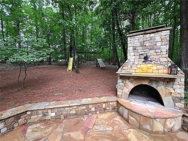 1045 River Pt, Suwanee, GA 30024 - view of patio / terrace with an outdoor stone fireplace and a playground