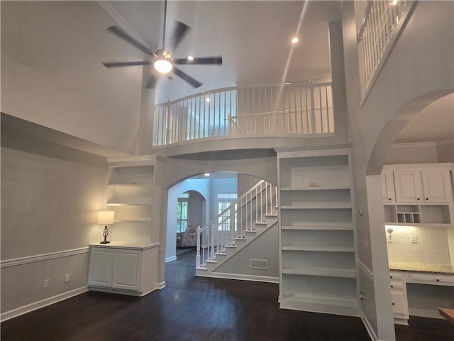 1045 River Pt, Suwanee, GA 30024 - stairway featuring arched walkways, a ceiling fan, wood finished floors, and a high ceiling