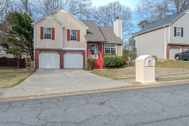 split level home featuring a front lawn, driveway, fence, brick siding, and a chimney