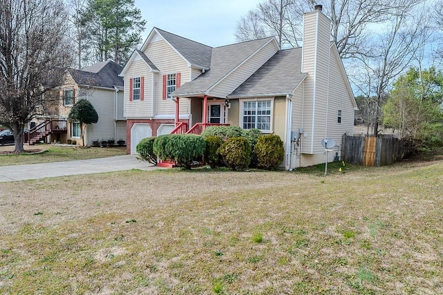 tri-level home featuring a garage, concrete driveway, a chimney, and a front yard