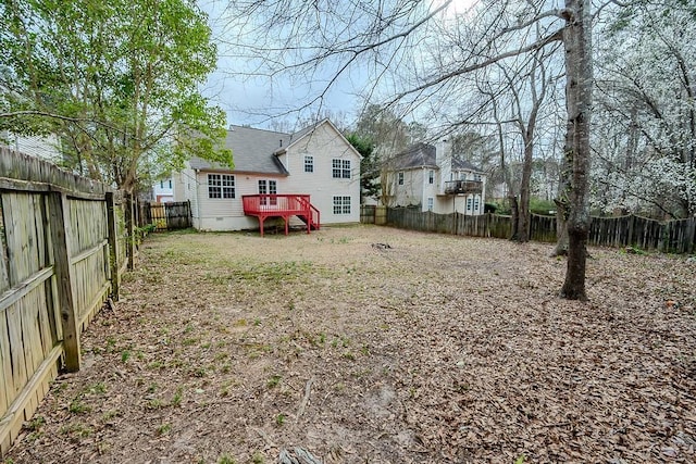 view of yard with a wooden deck and a fenced backyard