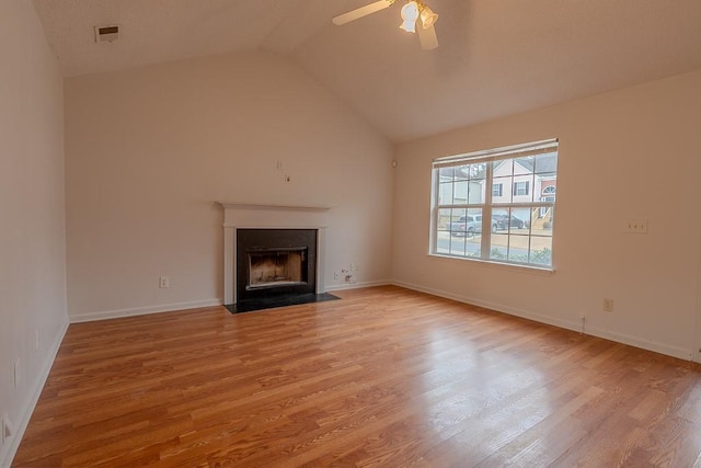 unfurnished living room featuring vaulted ceiling, visible vents, a fireplace with flush hearth, and wood finished floors