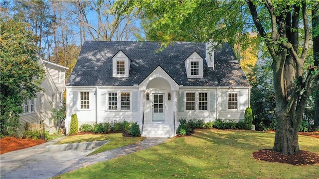 cape cod house featuring a front yard