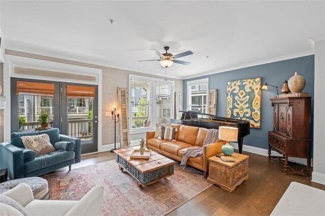 living area featuring crown molding, a ceiling fan, and baseboards