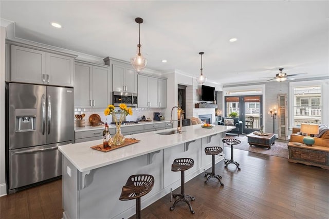 kitchen with a sink, appliances with stainless steel finishes, and gray cabinetry