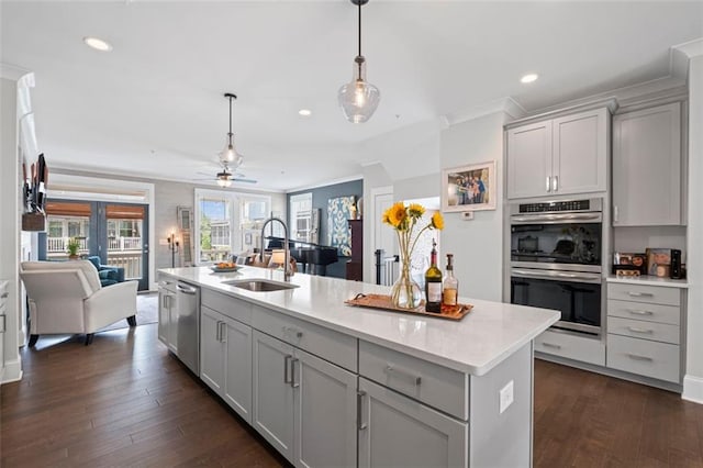 kitchen featuring appliances with stainless steel finishes, a sink, gray cabinetry, open floor plan, and recessed lighting