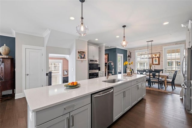 kitchen with a sink, dark wood-style floors, ornamental molding, stainless steel appliances, and recessed lighting