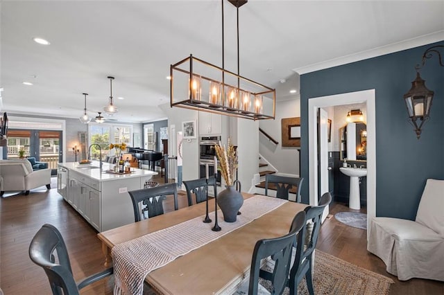 dining space with crown molding, stairs, dark wood finished floors, a notable chandelier, and recessed lighting